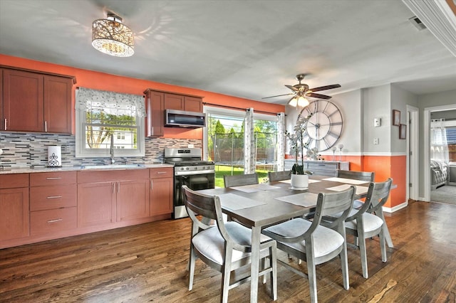 7937 S Lotus Ave, Burbank, IL 60459 - dining room featuring plenty of natural light, dark wood-style flooring, ceiling fan, a wainscoted wall, and baseboards