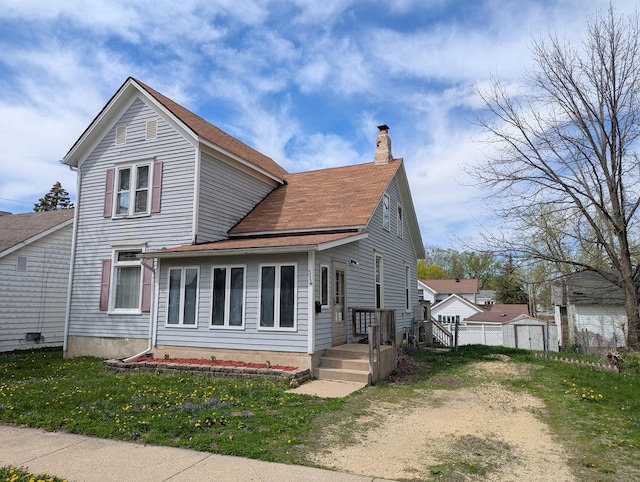 314 W Chestnut, Freeport, IL 61032 - traditional-style house with a chimney, a shingled roof, a front yard, and an outdoor structure