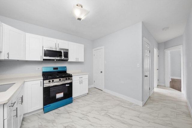 6742 S Honore St, Chicago, IL 60636 - kitchen featuring appliances with stainless steel finishes, light marble finish flooring, light countertops, and white cabinetry