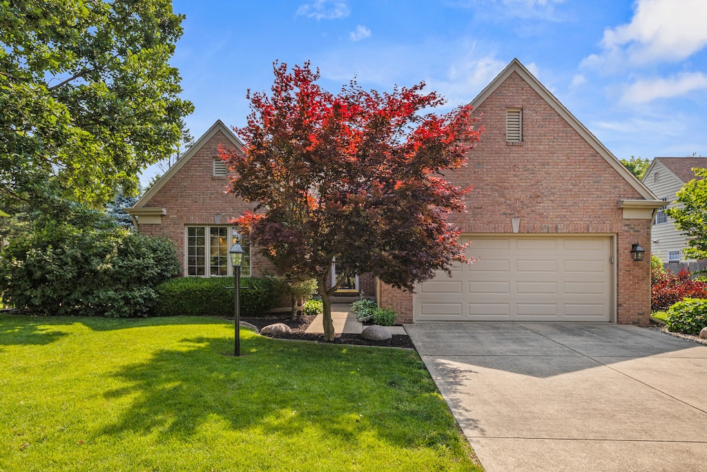 1714 Lakeside Dr, Champaign, IL 61821 - view of front of home with brick siding, a garage, driveway, and a front yard
