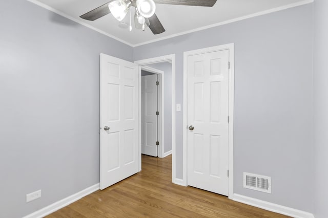 1205 N Irving Ave, Berkeley, IL 60163 - unfurnished bedroom with wood finished floors, baseboards, crown molding, and a ceiling fan