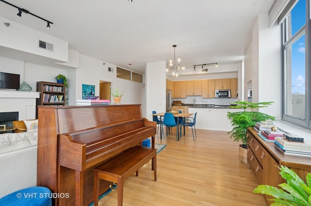 1201 W Adams St Unit 1001, Chicago, IL 60607 - living area featuring rail lighting, a chandelier, light wood-style flooring, and a fireplace