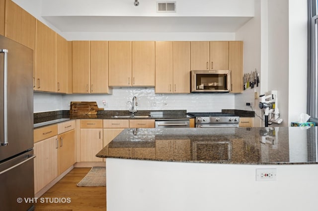 1201 W Adams St Unit 1001, Chicago, IL 60607 - kitchen featuring stainless steel appliances, light brown cabinets, dark stone countertops, and tasteful backsplash