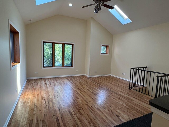 3037 W Polk Ave Unit 3, Chicago, IL 60612 - unfurnished living room with a skylight, a ceiling fan, wood finished floors, baseboards, and lofted ceiling