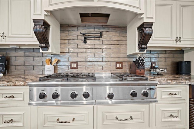 1810 Cardinal Ct, Pontiac, IL 61764 - kitchen with stainless steel gas stovetop, exhaust hood, tasteful backsplash, and light stone counters