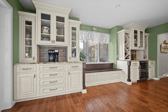 1810 Cardinal Ct, Pontiac, IL 61764 - kitchen featuring wine cooler, light stone countertops, dark wood finished floors, and glass insert cabinets