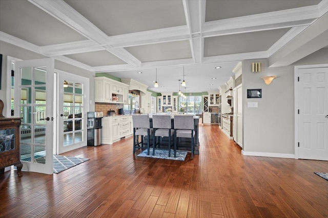 1810 Cardinal Ct, Pontiac, IL 61764 - kitchen featuring coffered ceiling, a breakfast bar, french doors, dark wood finished floors, and a center island with sink