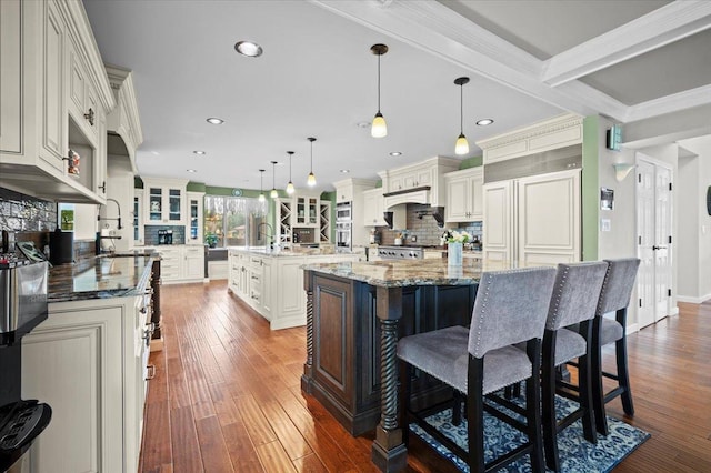1810 Cardinal Ct, Pontiac, IL 61764 - kitchen with a kitchen island with sink, decorative backsplash, dark wood finished floors, recessed lighting, and a breakfast bar