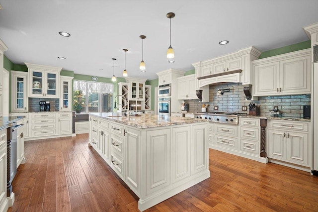 1810 Cardinal Ct, Pontiac, IL 61764 - kitchen with stainless steel gas cooktop, tasteful backsplash, dark wood finished floors, glass insert cabinets, and light stone counters
