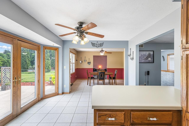 9650 Edgefield Rd, Roscoe, IL 61073 - kitchen with ceiling fan, light countertops, light tile patterned flooring, brown cabinetry, and a peninsula
