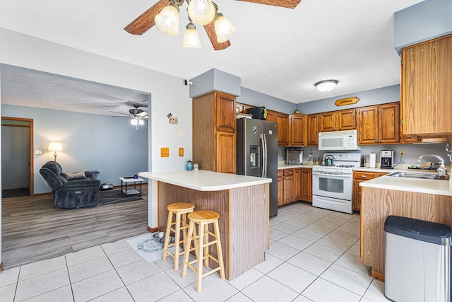 9650 Edgefield Rd, Roscoe, IL 61073 - kitchen with white appliances, a ceiling fan, a sink, a peninsula, and open floor plan