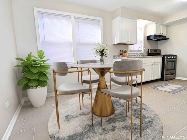 7056 S Honore St, Chicago, IL 60636 - kitchen featuring stainless steel gas range oven, light tile patterned floors, range hood, white cabinetry, and baseboards