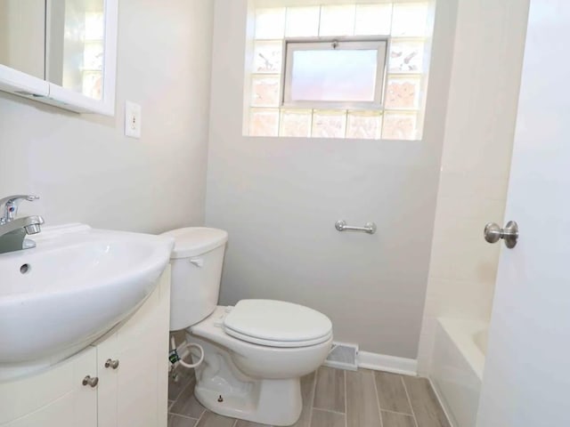 7056 S Honore St, Chicago, IL 60636 - bathroom featuring toilet, vanity, wood tiled floors, and baseboards