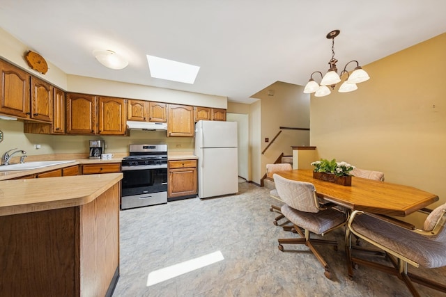 13040 W Tanglewood Cir, Palos Park, IL 60464 - kitchen with stainless steel gas stove, freestanding refrigerator, light countertops, under cabinet range hood, and a skylight