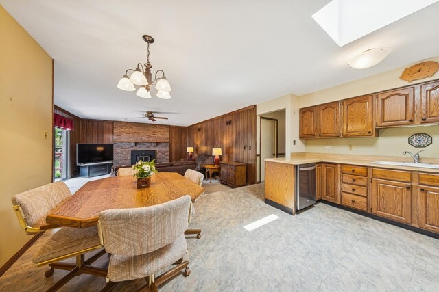 13040 W Tanglewood Cir, Palos Park, IL 60464 - dining room with a chandelier, wood walls, a brick fireplace, and a skylight
