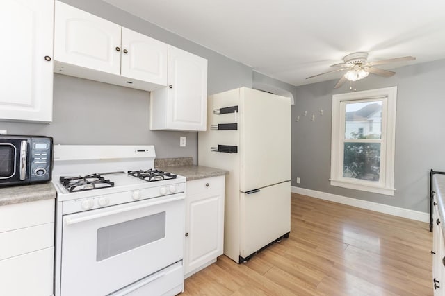 602 N Lee St, Bloomington, IL 61701 - kitchen featuring white appliances, light wood-style flooring, ceiling fan, and white cabinetry