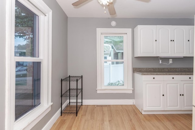 602 N Lee St, Bloomington, IL 61701 - kitchen featuring white cabinetry, light wood-style floors, dark countertops, and ceiling fan