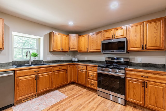 402 Lincoln St, Seatonville, IL 61359 - kitchen with stainless steel appliances, tile counters, light wood finished floors, recessed lighting, and brown cabinetry