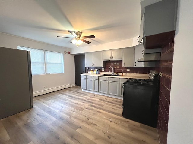 543 Geneva Ave Unit 104A, Bellwood, IL 60104 - kitchen featuring gas stove, baseboard heating, freestanding refrigerator, a sink, and gray cabinetry