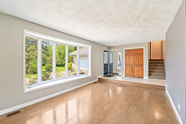 15807 W 139th St, Homer Glen, IL 60491 - unfurnished living room featuring light wood-style floors, stairway, and a textured ceiling