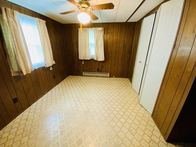 157 Prairie St, Ottawa, IL 61350 - spare room featuring a baseboard heating unit, wooden walls, and a ceiling fan