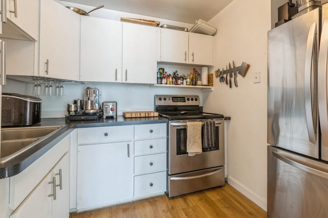 21 W Goethe St Unit 8K, Chicago, IL 60610 - kitchen featuring appliances with stainless steel finishes, light wood-type flooring, baseboards, white cabinetry, and dark countertops