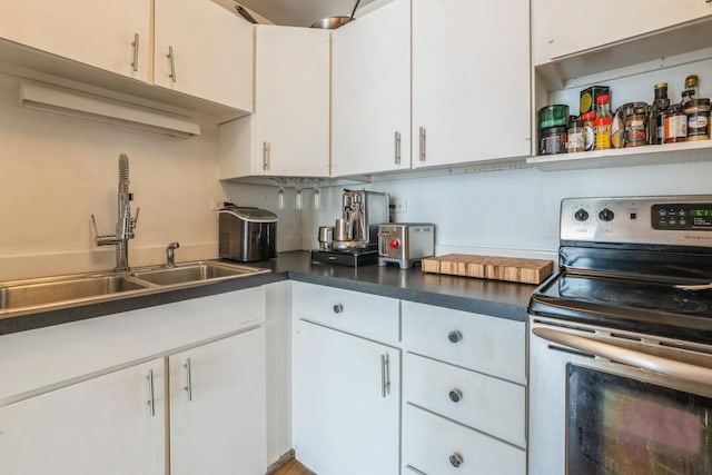 21 W Goethe St Unit 8K, Chicago, IL 60610 - kitchen with stainless steel electric range oven, a sink, white cabinetry, and dark countertops