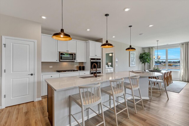 2804 Autumn Ridge Ct, Lindenhurst, IL 60046 - kitchen featuring stainless steel microwave, a sink, gas cooktop, light wood-style floors, and backsplash