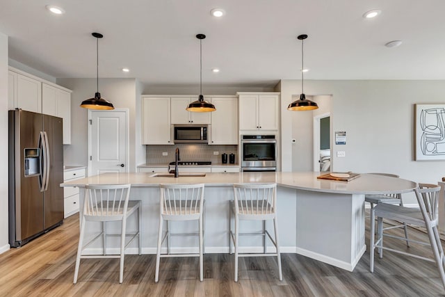 2804 Autumn Ridge Ct, Lindenhurst, IL 60046 - kitchen with stainless steel appliances, a sink, light wood finished floors, white cabinets, and backsplash