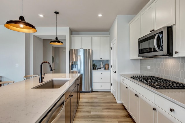 2804 Autumn Ridge Ct, Lindenhurst, IL 60046 - kitchen with appliances with stainless steel finishes, a sink, decorative light fixtures, backsplash, and light stone counters