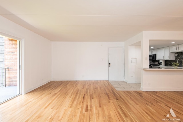 9146 W 140th St Unit 2Sw, Orland Park, IL 60462 - unfurnished living room featuring light wood finished floors, plenty of natural light, and baseboards