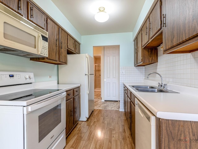 500 W Huntington Commons Rd Unit 150, Mount Prospect, IL 60056 - kitchen featuring white appliances, light wood-style floors, light countertops, and decorative backsplash