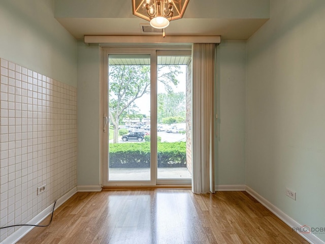 500 W Huntington Commons Rd Unit 150, Mount Prospect, IL 60056 - unfurnished room featuring wood finished floors and a chandelier