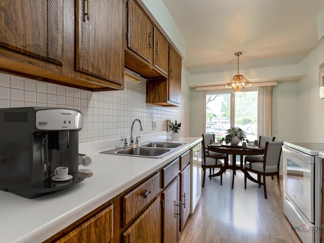 500 W Huntington Commons Rd Unit 150, Mount Prospect, IL 60056 - kitchen with white appliances, light wood-type flooring, tasteful backsplash, light countertops, and a chandelier