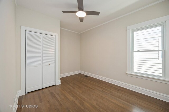 729 N Cuyler Ave, Oak Park, IL 60302 - unfurnished bedroom with dark wood-type flooring, multiple windows, a closet, crown molding, and a ceiling fan