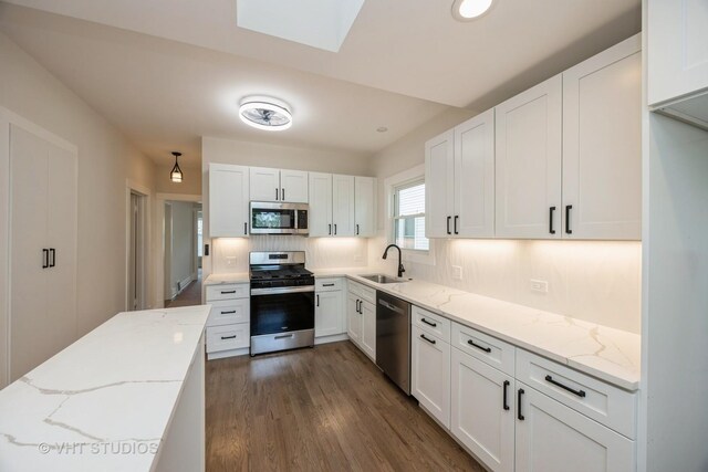 729 N Cuyler Ave, Oak Park, IL 60302 - kitchen featuring appliances with stainless steel finishes, white cabinets, tasteful backsplash, and light stone counters