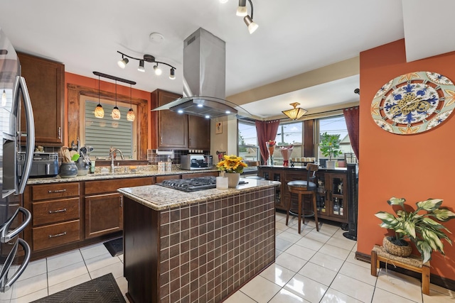5520 S Kildare Ave, Chicago, IL 60629 - kitchen with island range hood, light tile patterned flooring, a kitchen island, stainless steel appliances, and hanging light fixtures