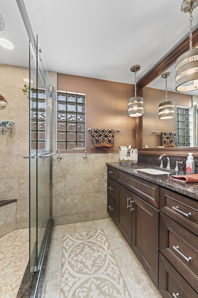 5520 S Kildare Ave, Chicago, IL 60629 - bathroom with vanity, a stall shower, tile walls, wainscoting, and tile patterned flooring