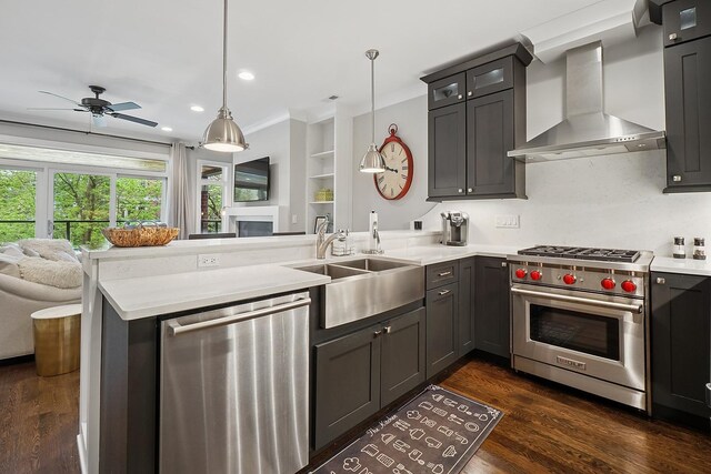 3740 N Kenmore Ave Unit 2, Chicago, IL 60613 - kitchen featuring appliances with stainless steel finishes, wall chimney exhaust hood, a sink, a peninsula, and open floor plan