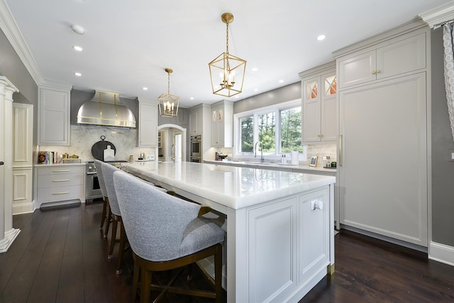 1877 Banbury Rd, Inverness, IL 60067 - kitchen featuring wall chimney exhaust hood, arched walkways, appliances with stainless steel finishes, dark wood-style flooring, and recessed lighting