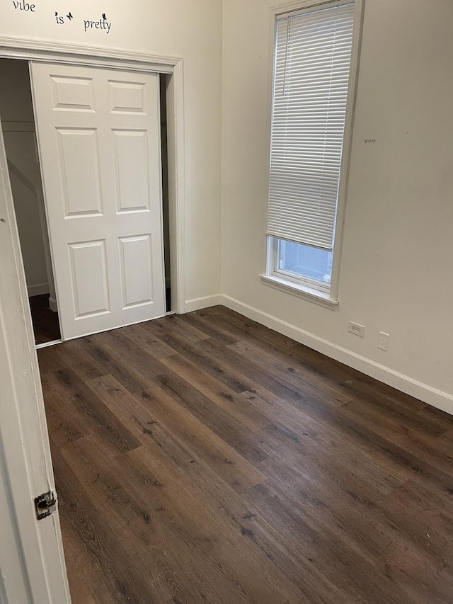 6907 S Cornell Ave, Chicago, IL 60649 - unfurnished bedroom featuring dark wood-style flooring, a closet, and baseboards