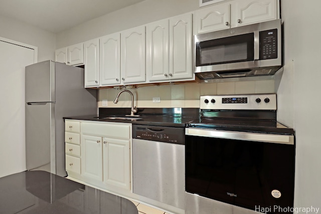 1567 Ridge Ave Unit 401, Evanston, IL 60201 - kitchen with appliances with stainless steel finishes, white cabinetry, dark countertops, and backsplash
