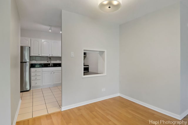 1567 Ridge Ave Unit 401, Evanston, IL 60201 - kitchen with freestanding refrigerator, white cabinets, dark countertops, light wood-style floors, and track lighting