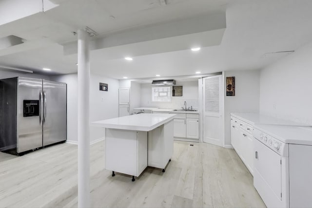 4118 Prairie Ave, Brookfield, IL 60513 - kitchen with stainless steel fridge, light wood-style flooring, light countertops, white cabinetry, and washer / dryer