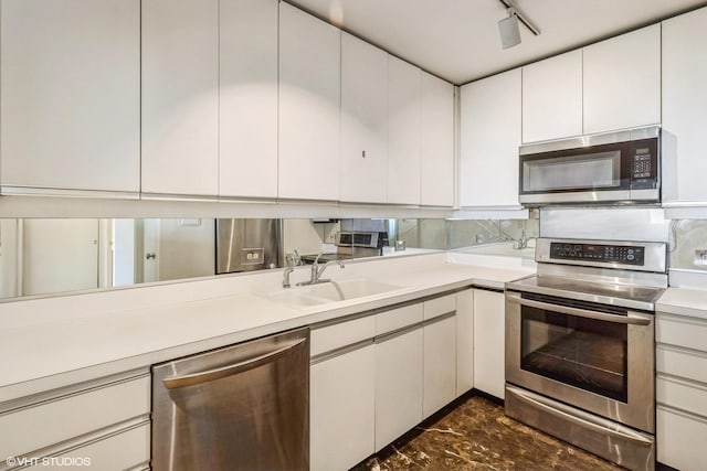 1550 N Lake Shore Dr Unit 32C, Chicago, IL 60610 - kitchen featuring stainless steel appliances, a sink, light countertops, white cabinetry, and backsplash