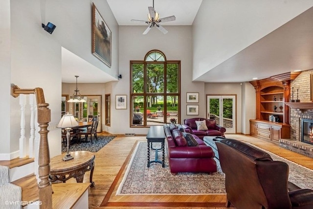 3104 Royal Fox Dr, Saint Charles, IL 60174 - living room featuring a towering ceiling, ceiling fan, wood finished floors, a brick fireplace, and built in shelves