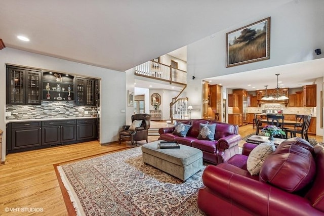 3104 Royal Fox Dr, Saint Charles, IL 60174 - living room with light wood-type flooring, bar with sink, stairway, and a high ceiling
