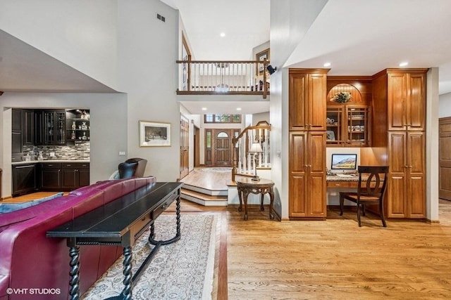 3104 Royal Fox Dr, Saint Charles, IL 60174 - living area featuring light wood-style flooring, a desk, a towering ceiling, recessed lighting, and bar area
