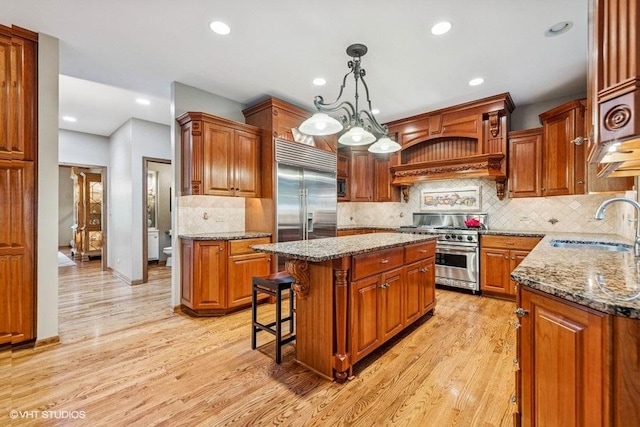 3104 Royal Fox Dr, Saint Charles, IL 60174 - kitchen featuring premium appliances, a center island, recessed lighting, light wood-type flooring, and brown cabinetry