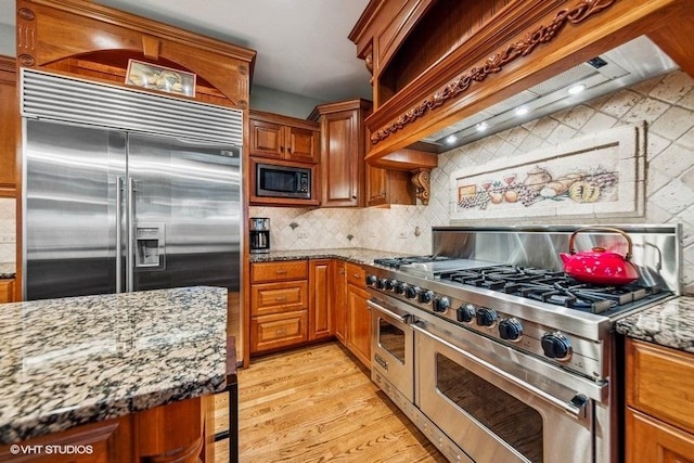 3104 Royal Fox Dr, Saint Charles, IL 60174 - kitchen with built in appliances, premium range hood, light wood finished floors, and brown cabinetry